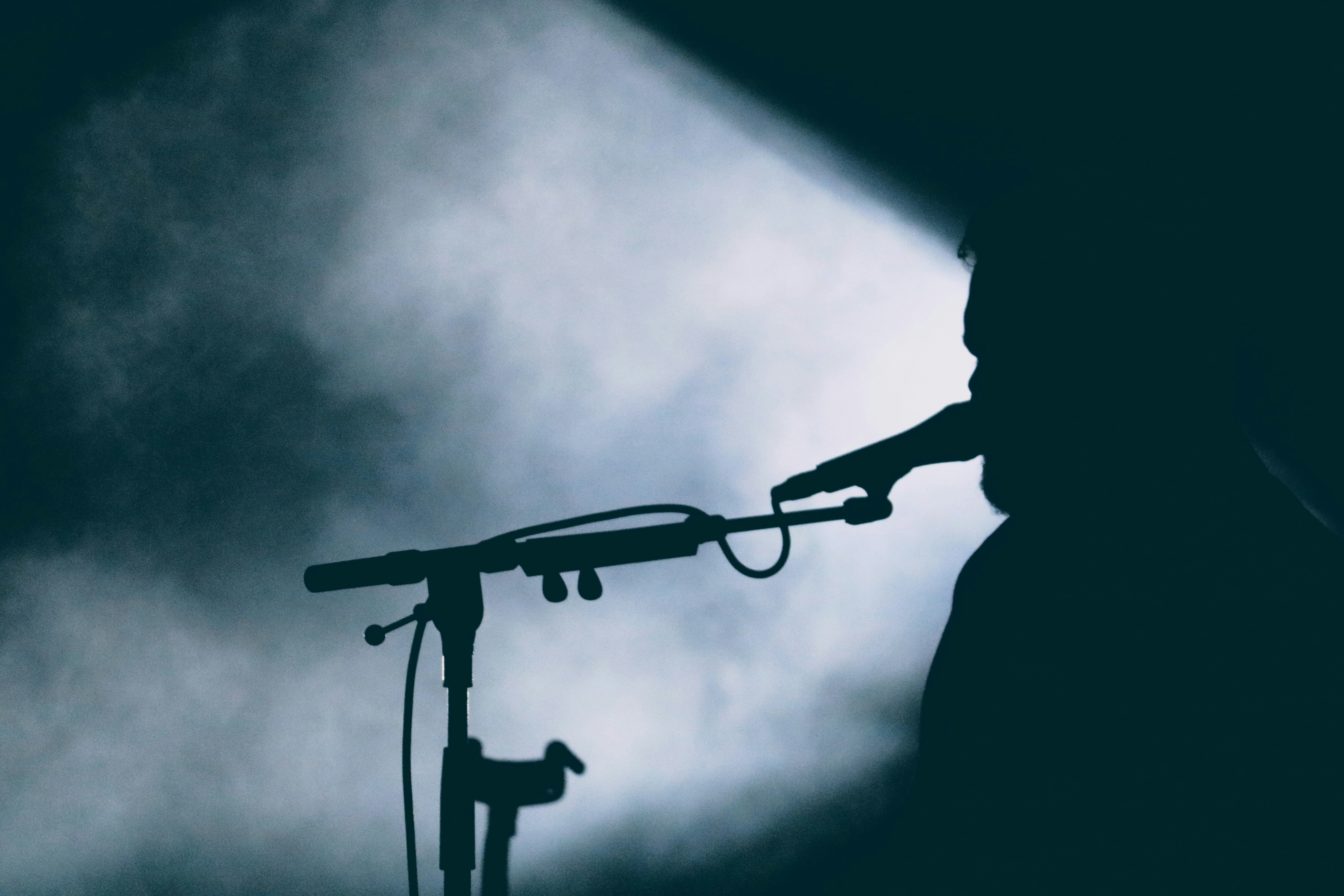 Image d'un chanteur de Soul dans l'ombre prise sur Unsplash pour représenter le chanteur de jazz et de soul O.C Smith